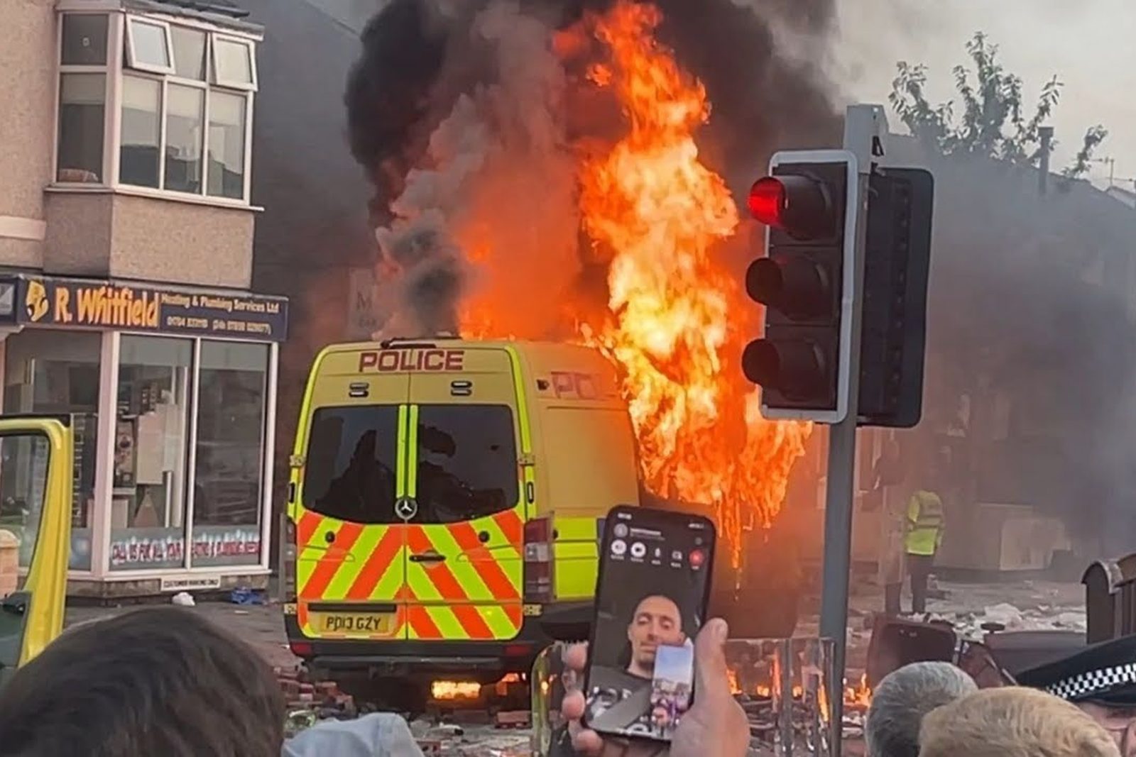 A police van burning in the street during the Southport riots.